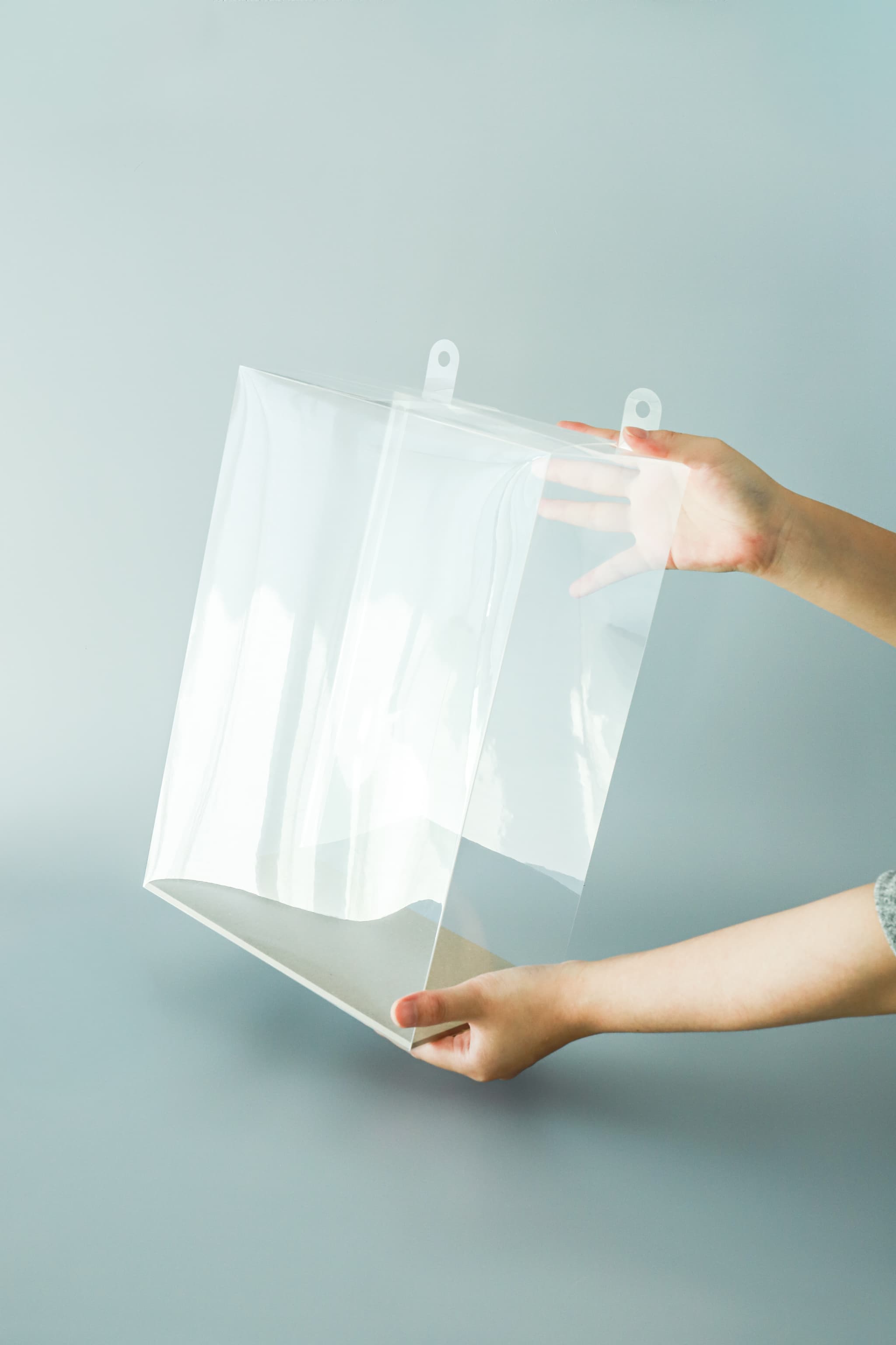 透明なプラスチックを持つ手