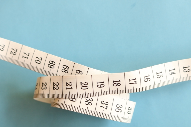 青い背景に置かれた巻尺の写真